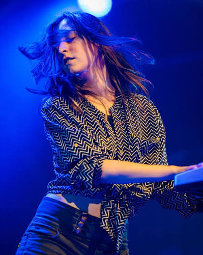 Luna Škopelja performing live on keyboards under blue stage light